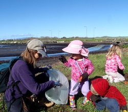 Family picking up trash by Bay