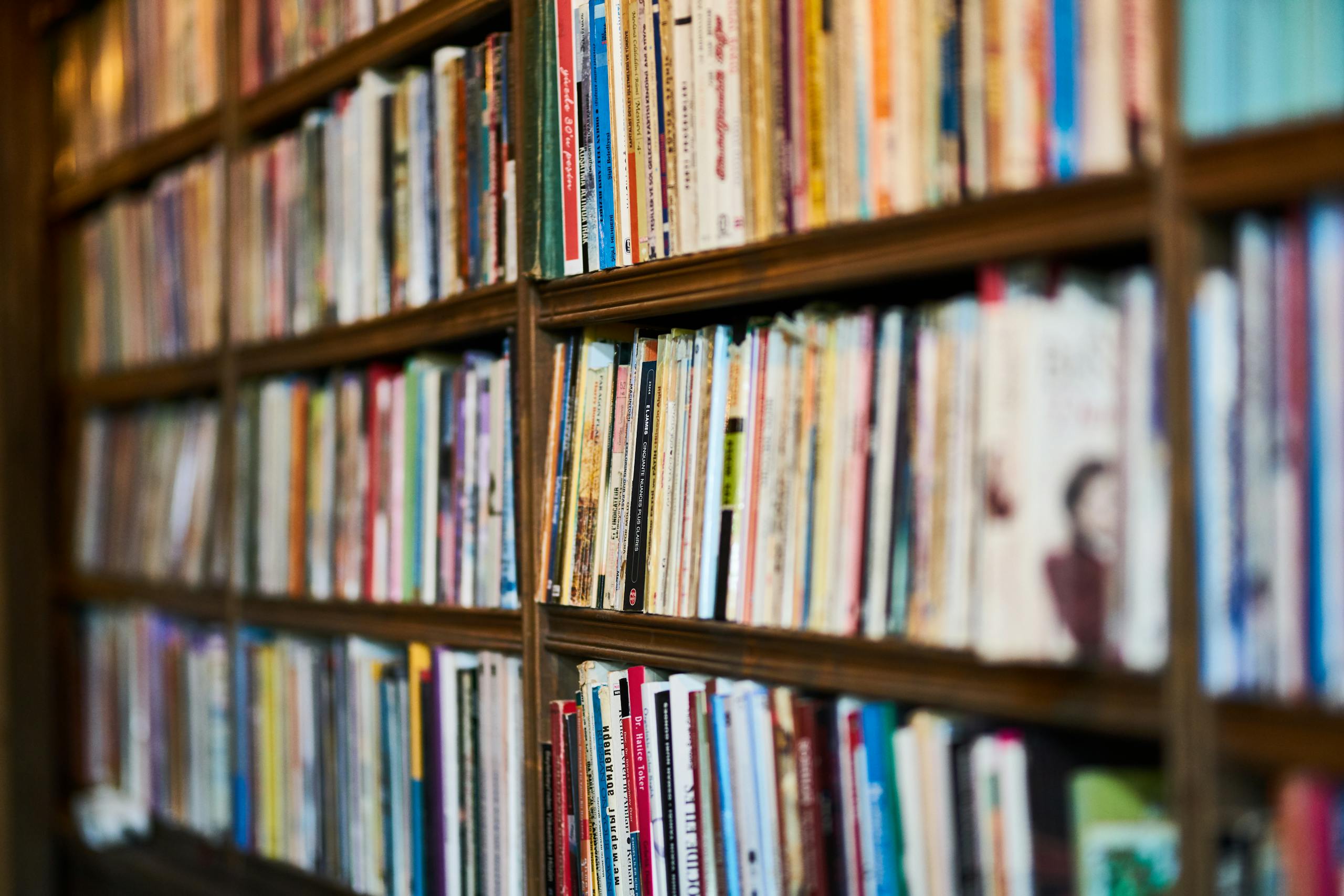 A detailed close-up view of a bookshelf in a library, showcasing various books.